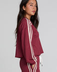 Side view of a woman wearing the Chaser Kloud Burnt Red Sweatshirt on a neutral background with matching pants