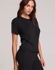 Front  angled view of a woman wearing the Chaser   Leonor Black Tee on a neutral background with black pants