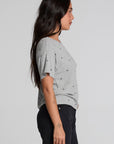 Side view of a woman wearing the Chaser Leonor Light Heather Grey Tee on a neutral background with pants
