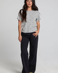 Full body view of a woman wearing the Chaser Leonor Light Heather Grey Tee on a neutral background with black pants and sneakers