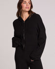 Front view of a woman wearing the Chaser Lizbeth Black Hoodie Jacket and black pants on a neutral background