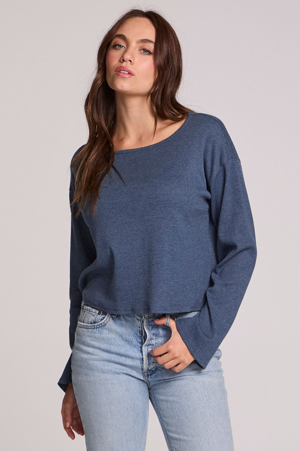 Front view of a woman wearing the Chaser Lunnah Dark Denim Top and blue jeans on a neutral background 