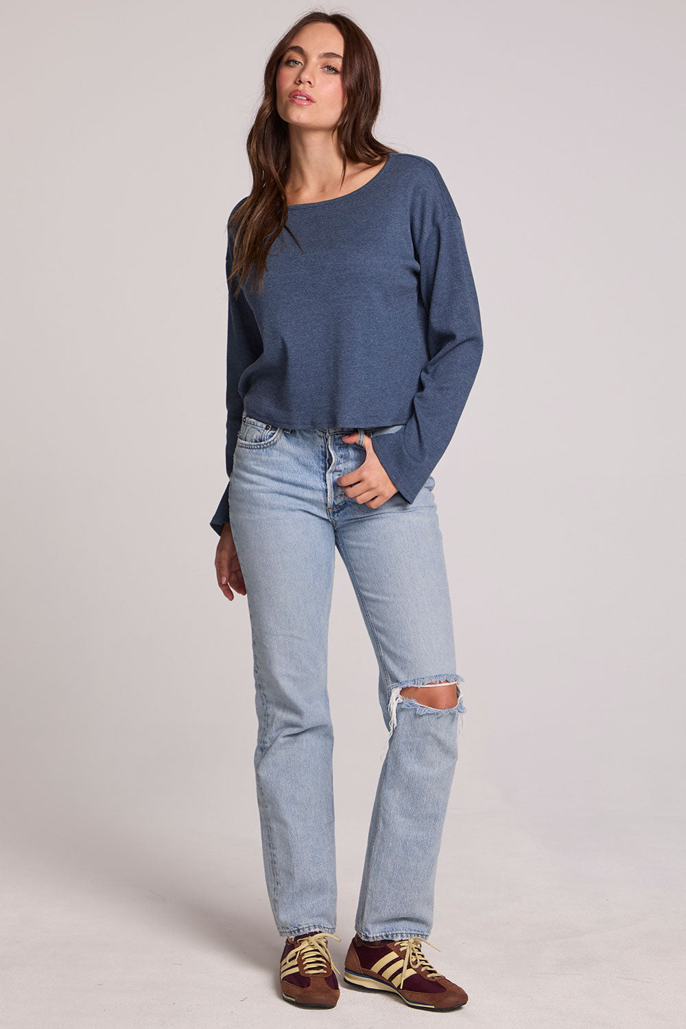 Full body front view of a woman wearing the Chaser Lunnah Dark Denim Top and blue jeans on a neutral background 