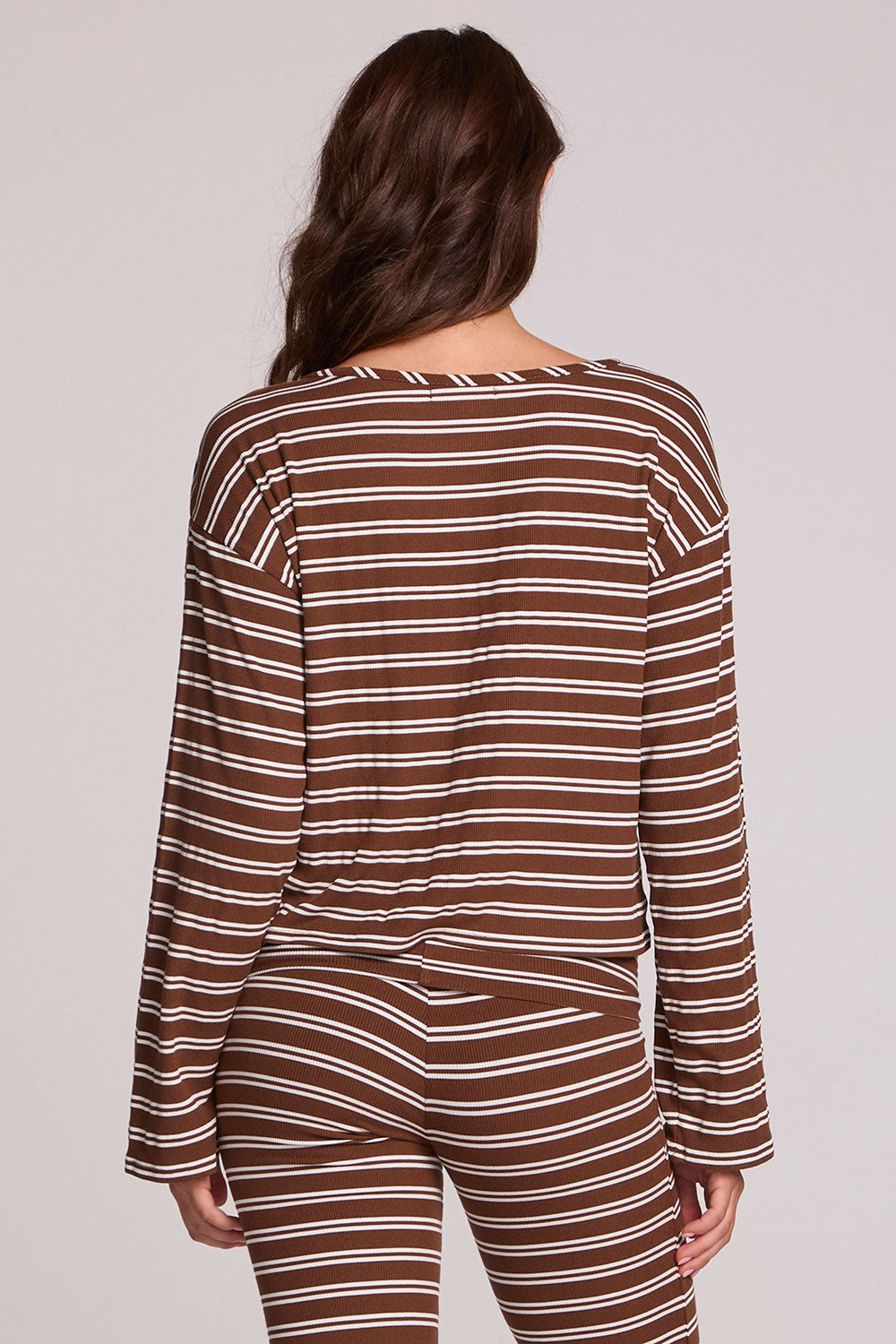Back view of a woman wearing the Chaser Lunnah Nutty Brown Top and matching striped pants on a neutral background 
