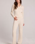 Full body front view of a woman wearing the Chaser  Mariya Amtique White Pants on a neutral background with matching top and black shoes