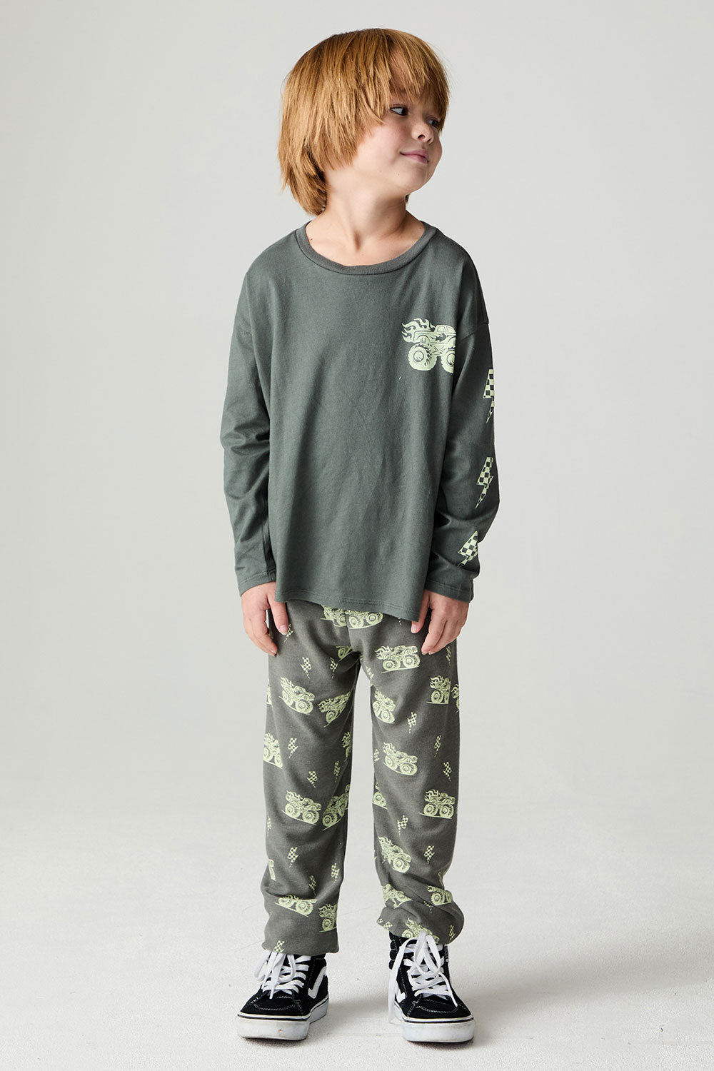 A full body front view of a boy wearing the Chaser Monster Truck Boys Tee on a neutral background