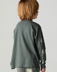 Back view of a boy wearing the Chaser Monster Truck Boys Tee on a neutral background with pants