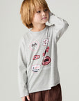 Front view of a boy wearing the Chaser Moto Patches Boys Tee on a neutral background with one hand on face