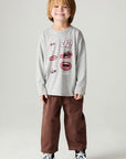A full body front view of a boy wearing the Chaser Moto Patches Boys Tee on a neutral background