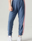 Front view of a girl wearing the Chaser Multi Stripes Girls Jogger on a neutral background with hand on hip