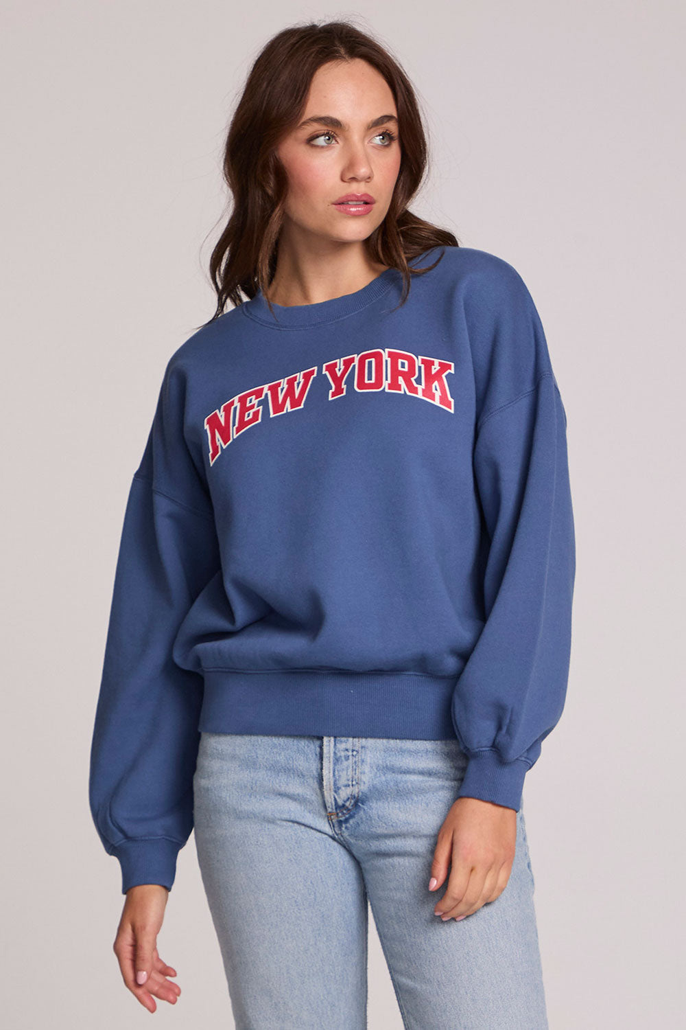 Front view of a woman wearing the Chaser New York Tee on a neutral background