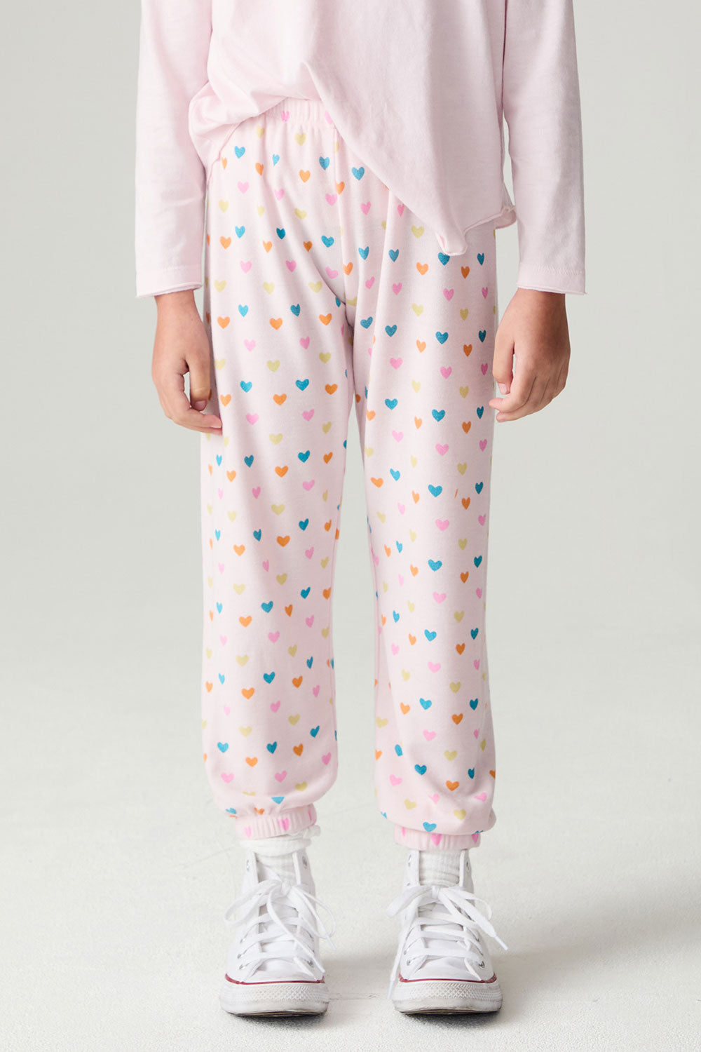Front view of a girl wearing the Chaser Party Hearts Girls Jogger on a neutral background with hands at sides and shirt