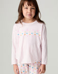 Front view of a girl wearing the Chaser Party Hearts Girls Tee on a neutral background with matching shirt