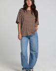 A full body front view of a woman wearing the Chaser Peri Nutty Brown Stripe Tee on a neutral background