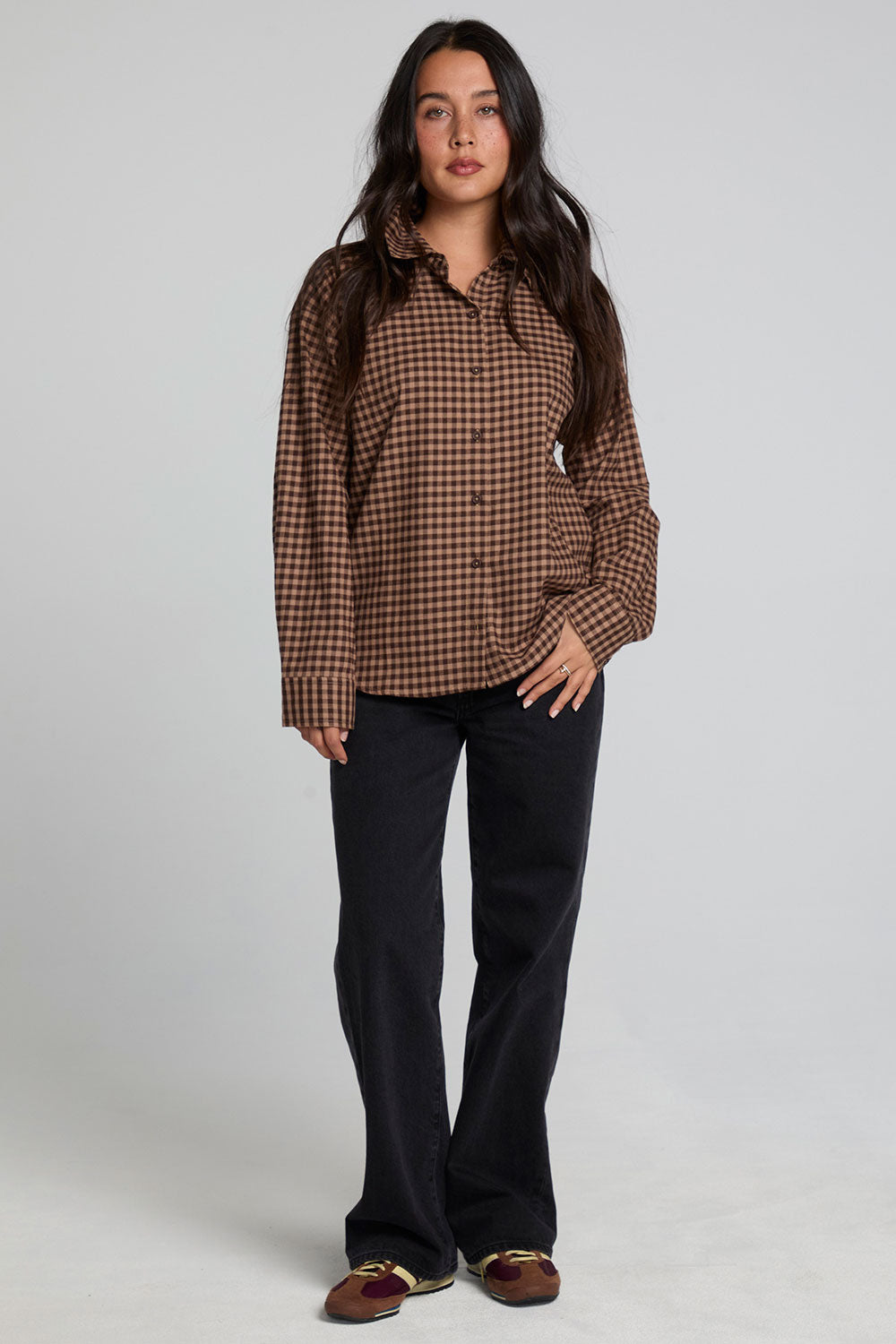 Full body front view of a woman wearing the Chaser Pine button down on a neutral background with black pants