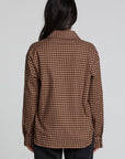 Back view of a woman wearing the Chaser Pine button down on a neutral background with arms down