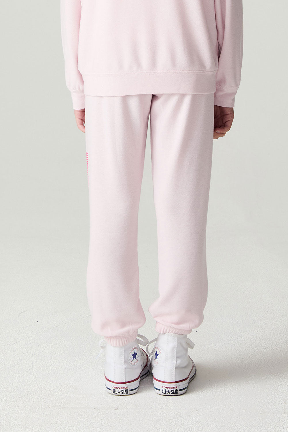 Back view of a girl wearing the Chaser Power Bolt Girls Jogger on a neutral background