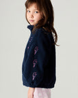 Side view of a girl wearing the Chaser Power Love Girls Jacket on a neutral background with arms at sides