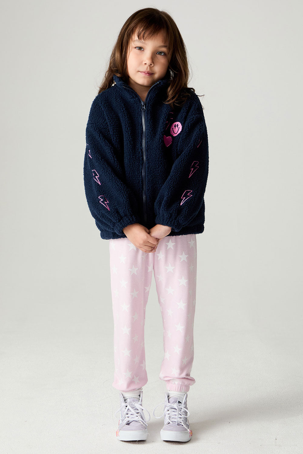 A full body front view of a girl wearing the Chaser Power Love Girls Jacket on a neutral background