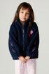Front view of a girl wearing the Chaser Power Love Girls Jacket on a neutral background with pink pants
