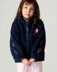 Front view of a girl wearing the Chaser Power Love Girls Jacket on a neutral background with pink pants