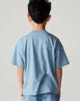 Back view of a boy wearing the Chaser Racers Boys Tee on a neutral background with jeans