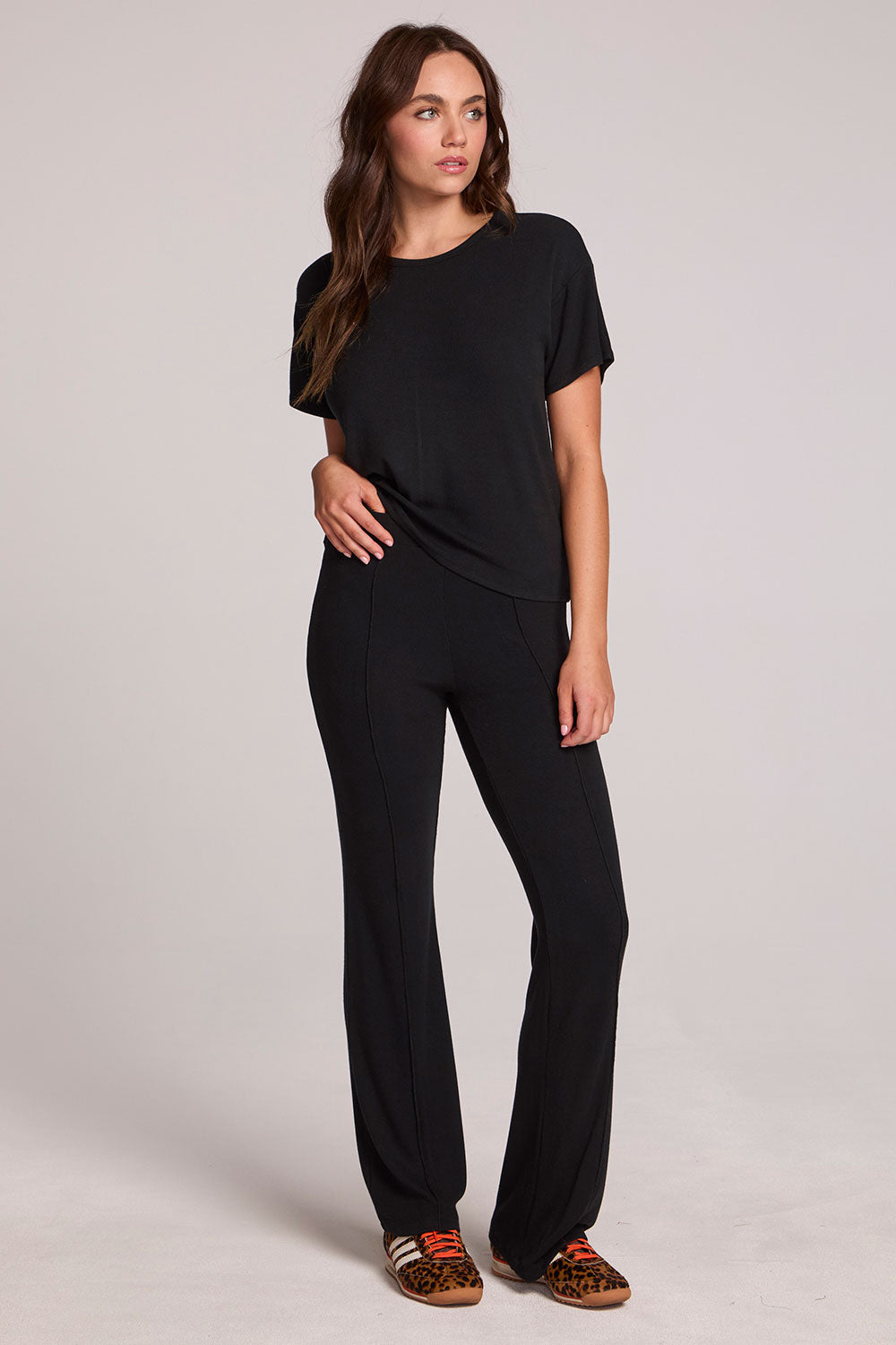 A full body front view of a woman wearing the Chaser Rhose Black Pants on a neutral background