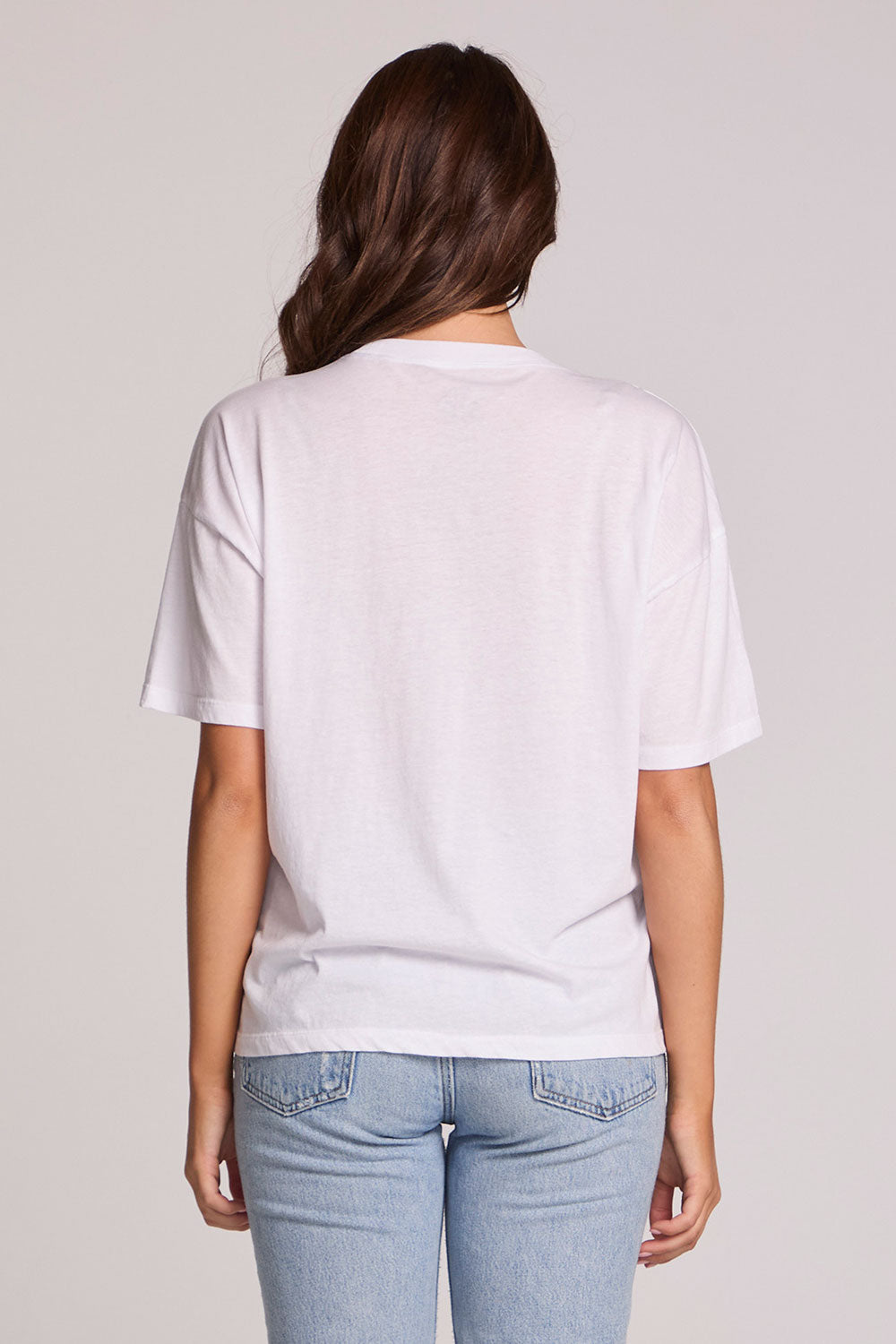 Back view of a woman wearing the Chaser Rodeo Show Tee on a neutral background with jeans