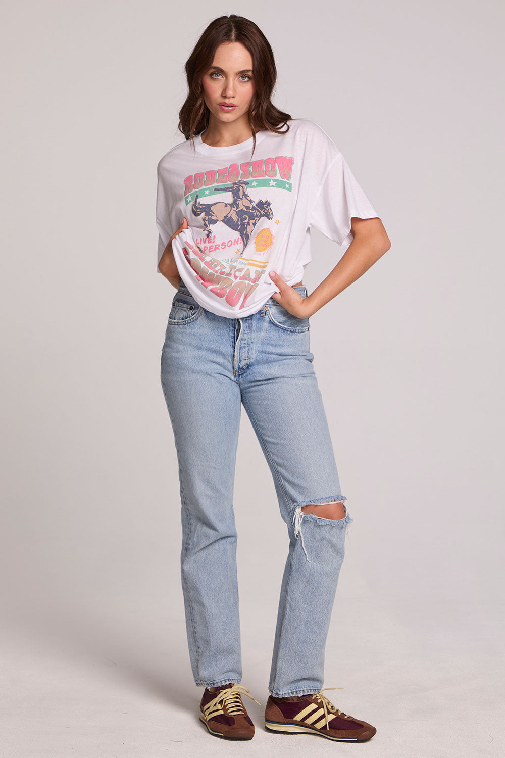 A full body front view of a woman wearing the Chaser Rodeo Show Tee on a neutral background