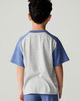  Back view of a boy wearing the Chaser Rookie Boys Tee on a neutral background with arms at sides and pants