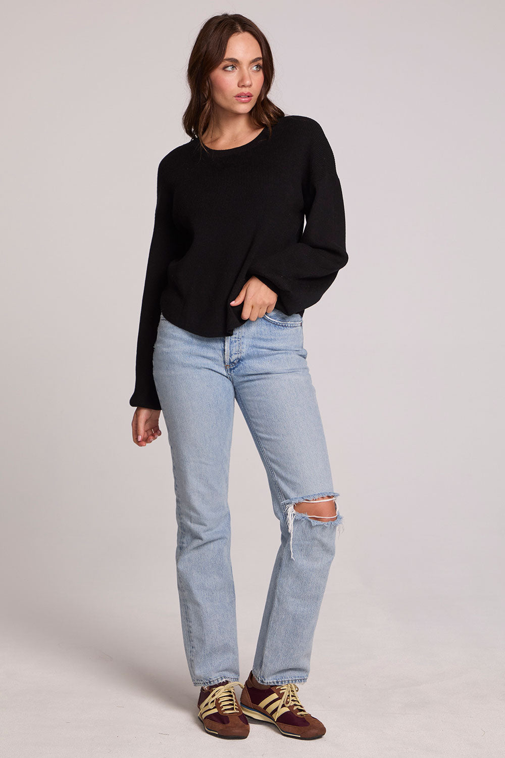 A full body front view of a woman wearing the Chaser Ruthy Black Fullsleeve Top on a neutral background