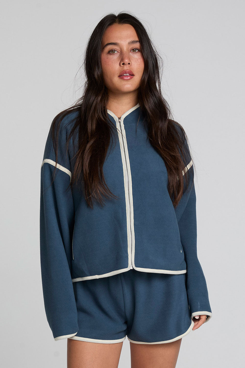 Front view of a woman wearing the Chaser Sharun Dark Denim Jacket on a neutral background