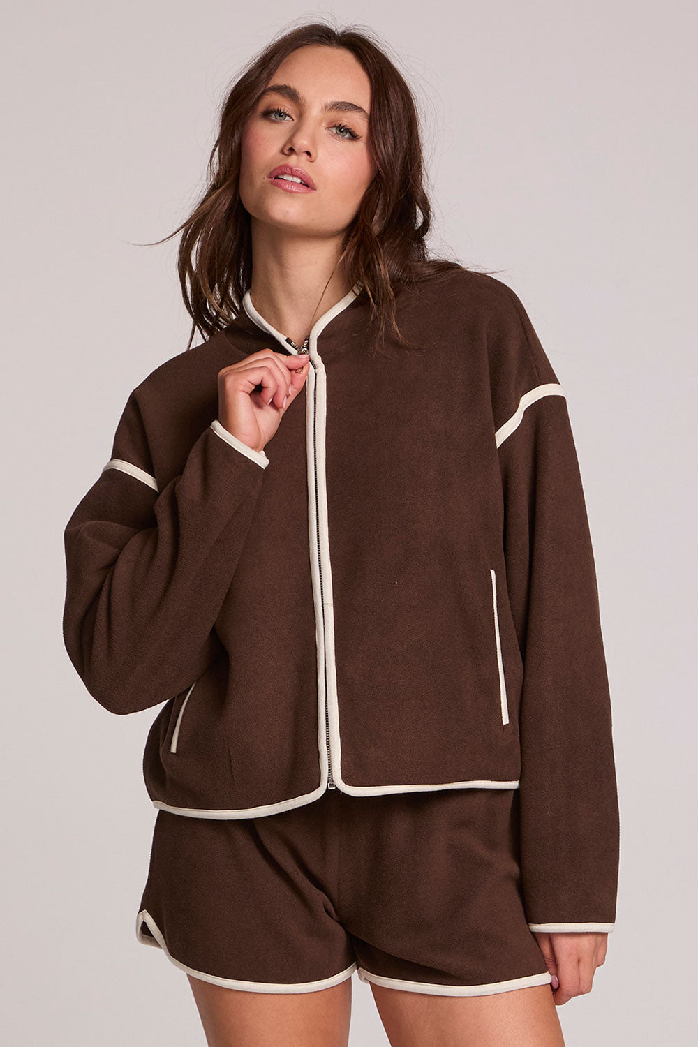 Front view of a woman wearing the Chaser Sharun Worn Brown Jacket on a neutral background