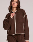 Front view of a woman wearing the Chaser Sharun Worn Brown Jacket on a neutral background