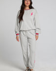 Full body front view of a woman wearing the Chaser  Shocking Bolt Pants on a neutral background with arms lowered at sides and matching long sleeve