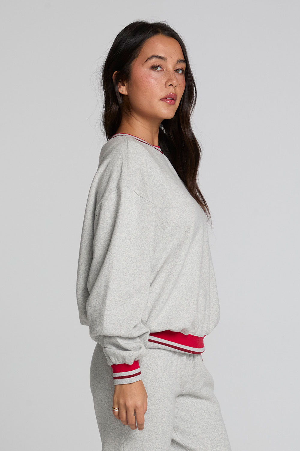 Side view of a woman wearing the Chaser Shocking Bolt Sweatshirt on a neutral background with matching pants