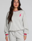 Front view of a woman wearing the Chaser Shocking Bolt Sweatshirt on a neutral background with matching grey pants