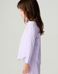 Side view of a girl wearing the Chaser Shocking Love Girls Tee on a neutral background with shirt