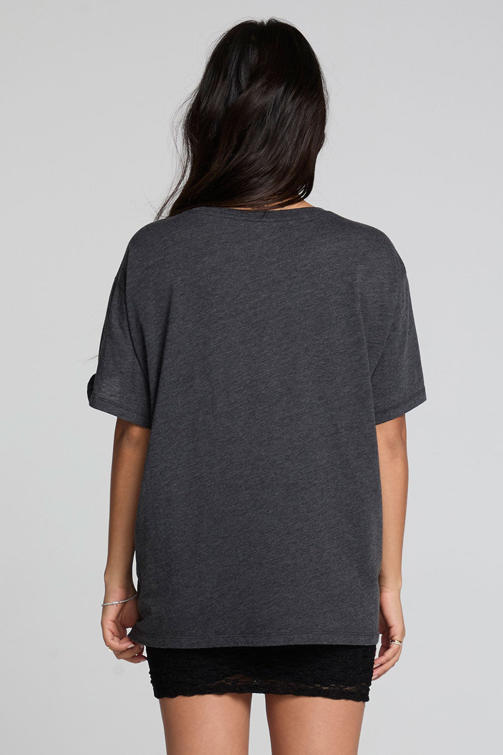 Back  view of a woman wearing the Chaser Socal Motorcycles Tee and black skirt on a neutral background