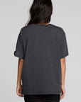 Back  view of a woman wearing the Chaser Socal Motorcycles Tee and black skirt on a neutral background