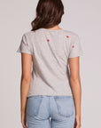 Back view of a woman wearing the Chaser Star Setter Cropped Tee on a neutral background with jeans and hands at sides
