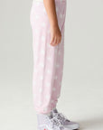 Side view of a girl wearing the Chaser Stars Allover Girls Jogger on a neutral background with sneakers