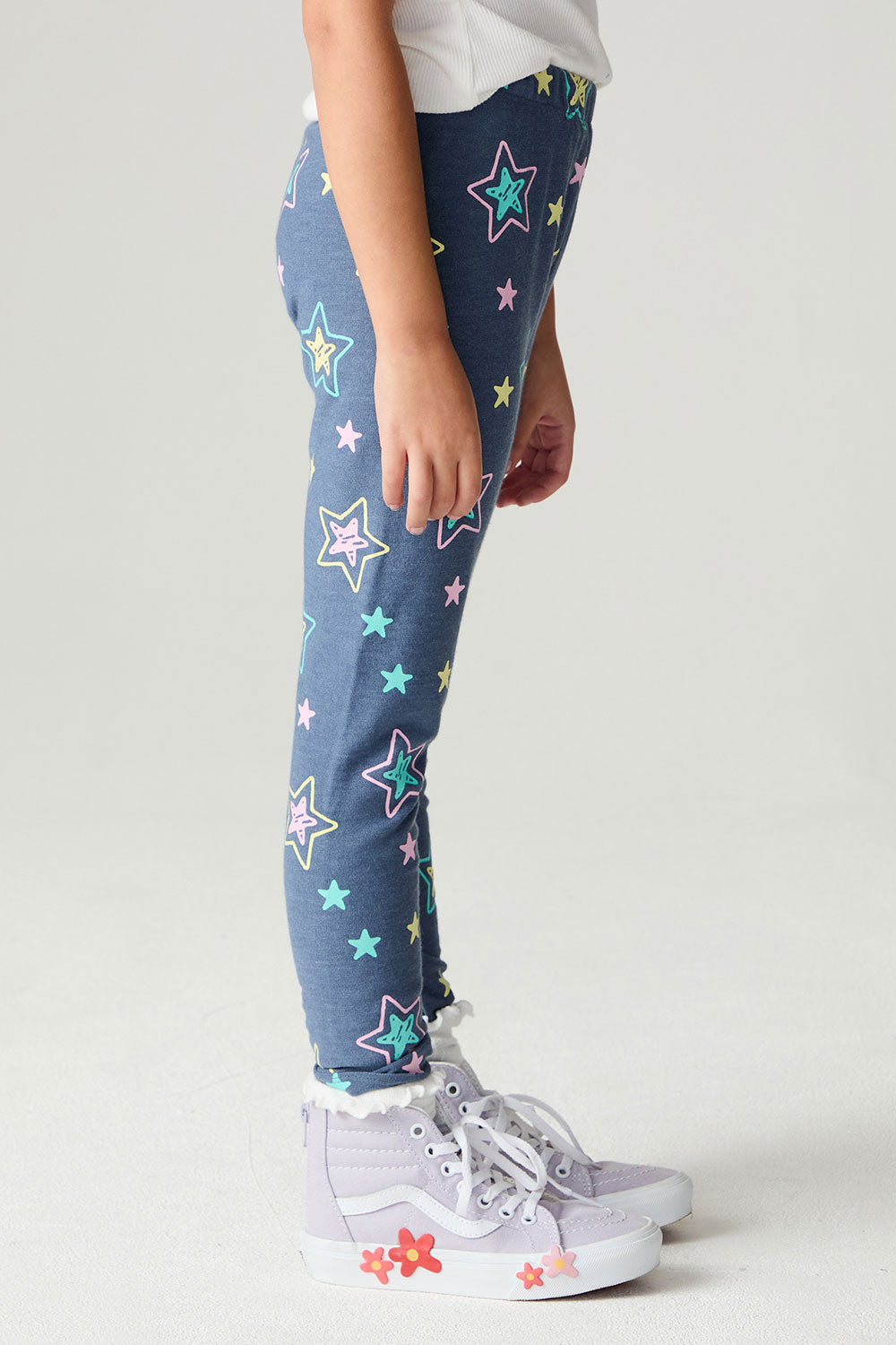 Side view of a girl wearing the Chaser Super Star Girls Joggers on a neutral background with arms at sides