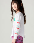 Side view of a girl wearing the Chaser Sweethearts Girls Tee on a neutral background with pink pants