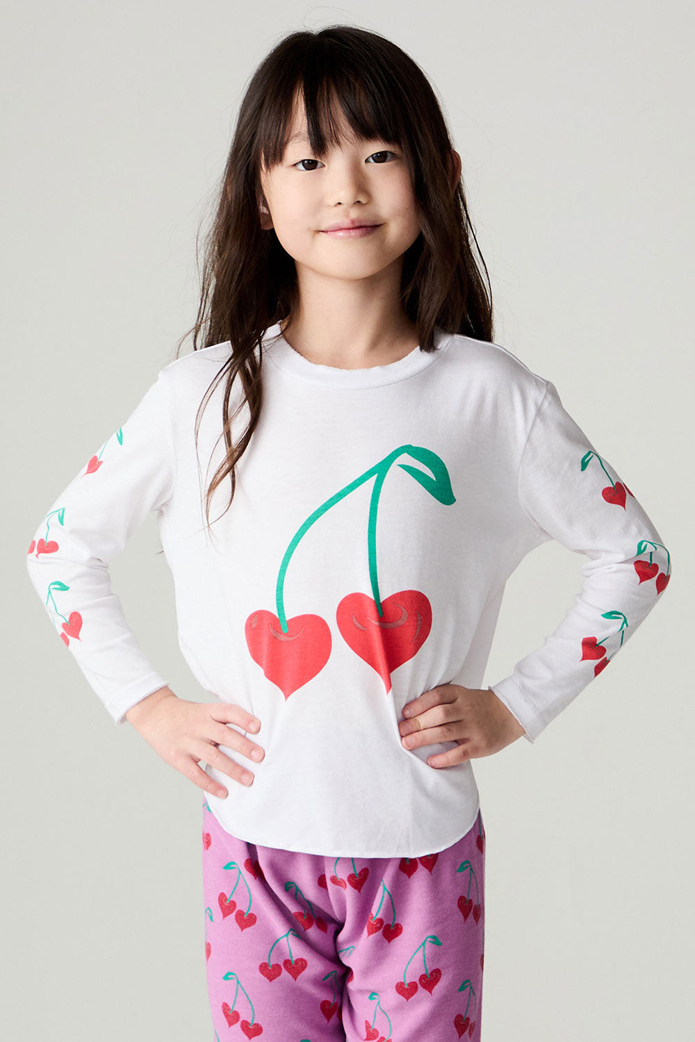 Front view of a girl wearing the Chaser Sweethearts Girls Tee on a neutral background with matching pink pants