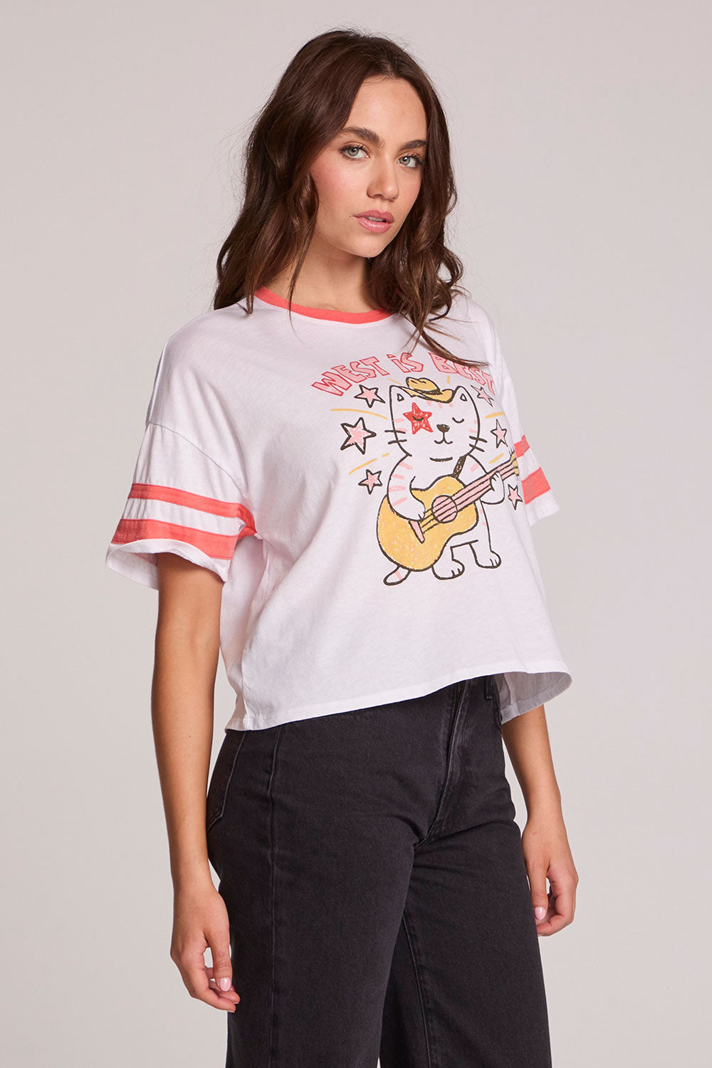 Side angle view of a woman wearing the Chaser Teddy Tee on a neutral background and black pants