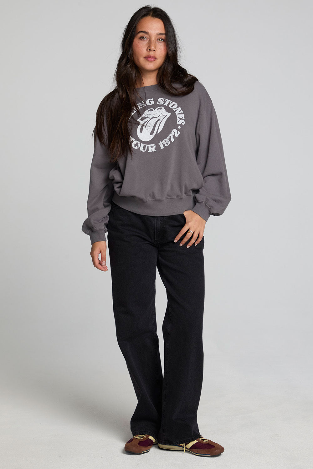 A full body front view of a woman wearing the Chaser The Rolling Stones 78 Tour Cropped Sweatshirt on a neutral background