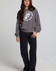 A full body front view of a woman wearing the Chaser The Rolling Stones 78 Tour Cropped Sweatshirt on a neutral background