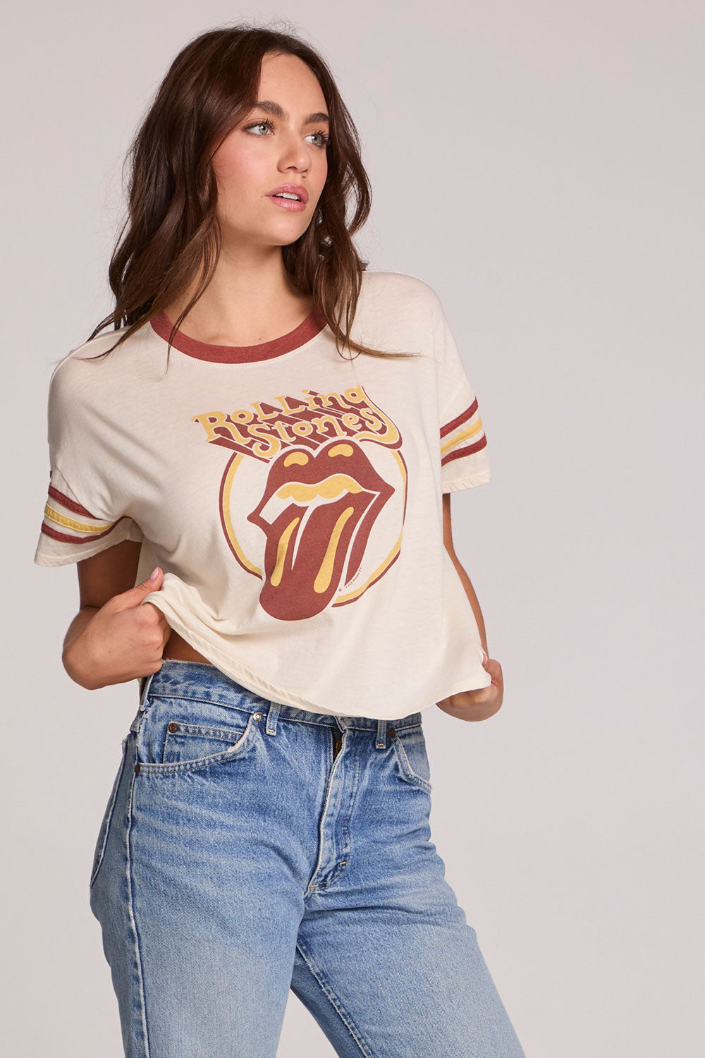 Front view of a woman wearing the Chaser  The Rolling Stones Retro Tongue Tee on a neutral background with jeans
