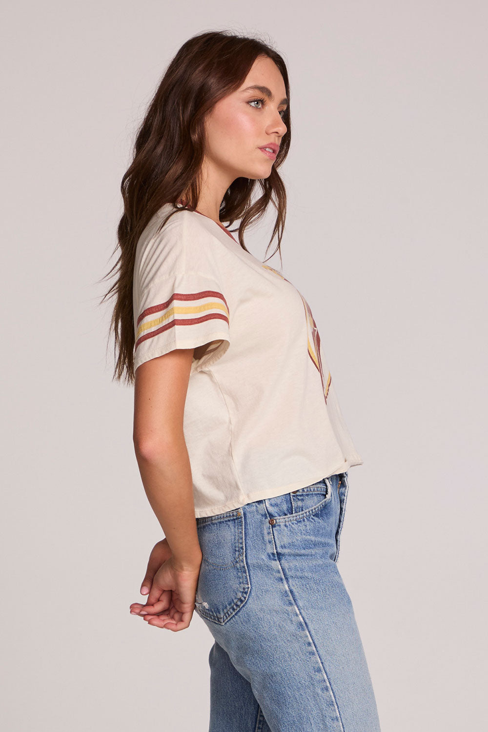 Side view of a woman wearing the Chaser  The Rolling Stones Retro Tongue Tee on a neutral background